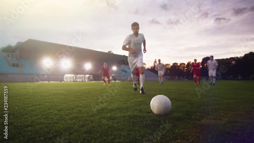 Professional Soccer Player Outruns Members of Opposing Team and Kicks Ball and Scores Goal. His Team Celebrates Victory. Cinematic Slow Motion. photo