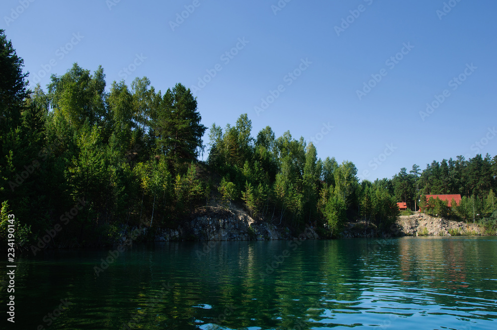 mountain lake in the summer at noon with vacationers and swimming tourists mountain lake in the summer at noon with vacationers and swimming tourists