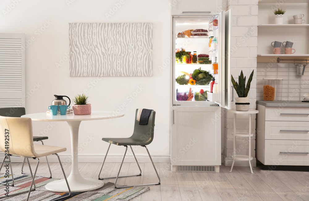 Fototapeta premium Stylish kitchen interior with refrigerator full of products