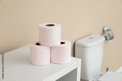 Toilet paper rolls on cabinet in bathroom