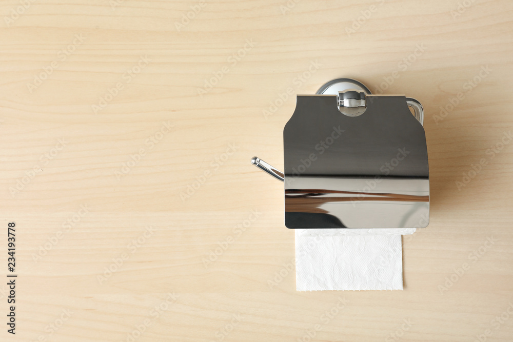 Holder with toilet paper roll on wooden background. Space for text Holder with toilet paper roll on wooden background. Space for text