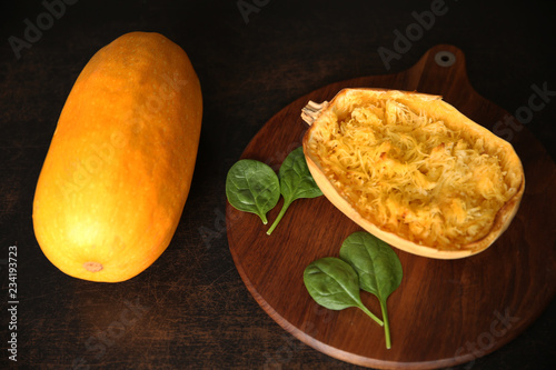 pumpkin spaghetti cooked and raw on the brown background with copy space for text or image. Flat lay. Top view.