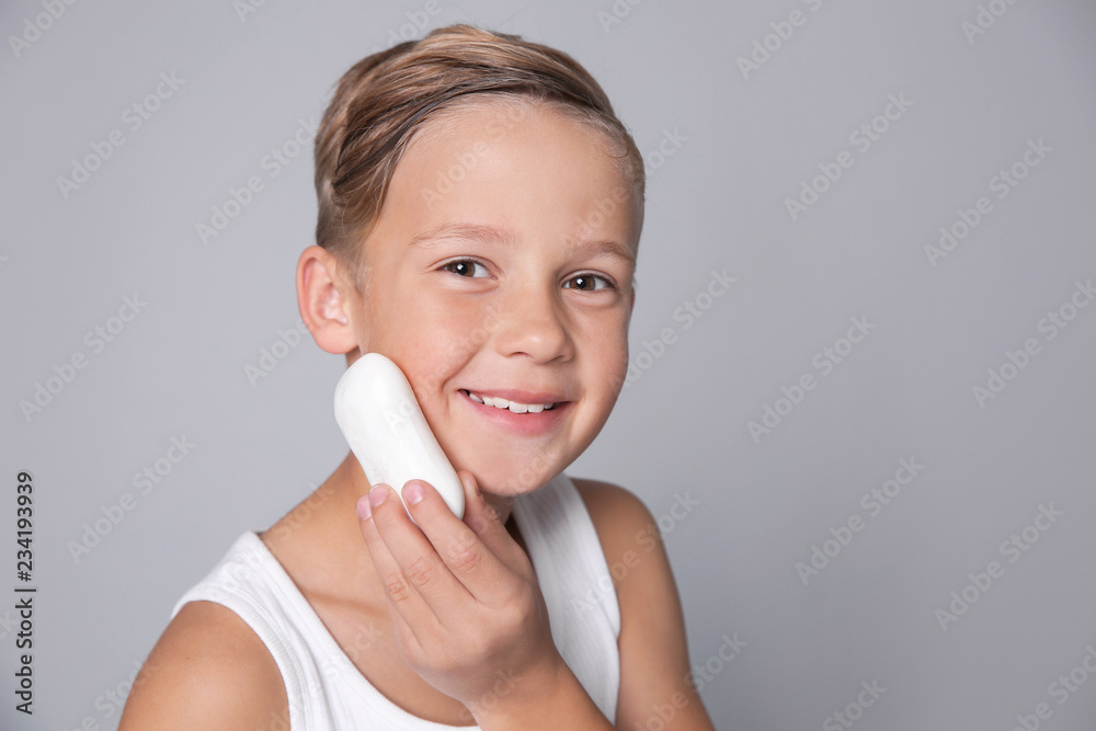 Cute little boy with soap bar on gray background Cute little boy with soap bar on gray background