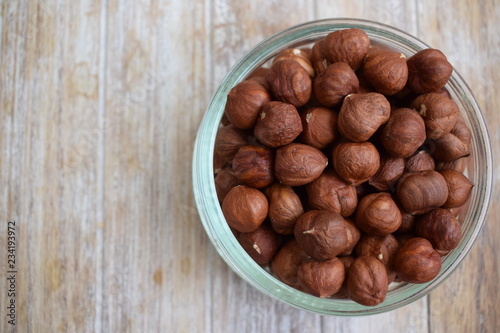 Hazelnuts in a glass jar in the background of the tree. Copy space.