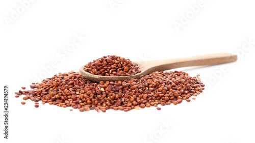 Pile of red quinoa and spoon on white background