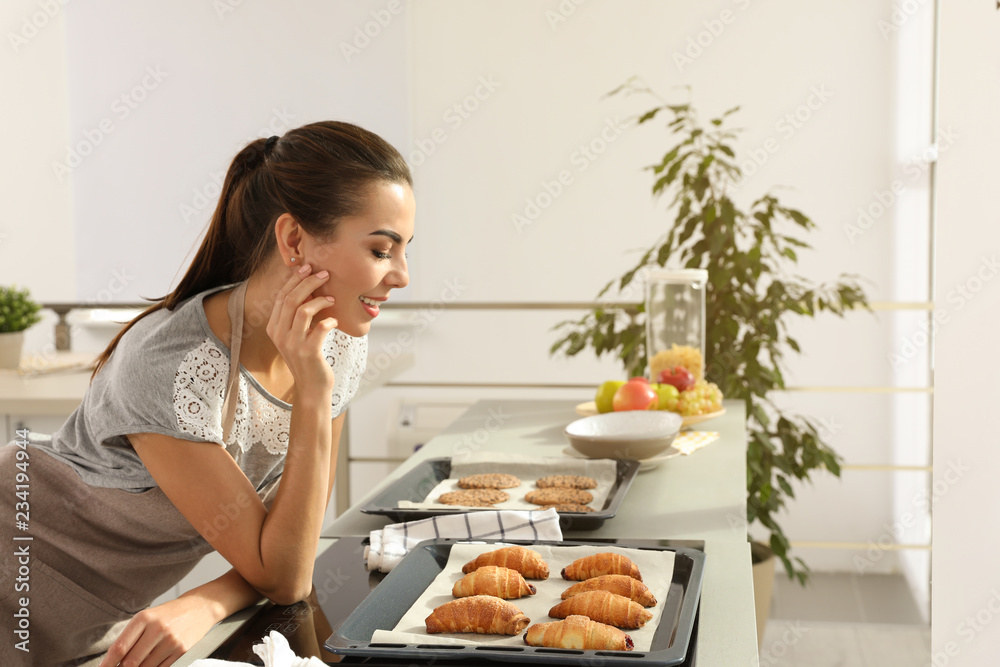Young woman with homemade oven baked pastry in kitchen Young woman with homemade oven baked pastry in kitchen