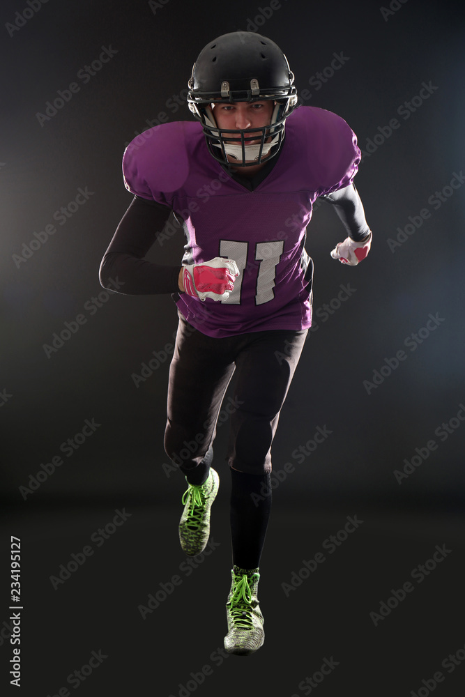 American football player wearing uniform on dark background American football player wearing uniform on dark background