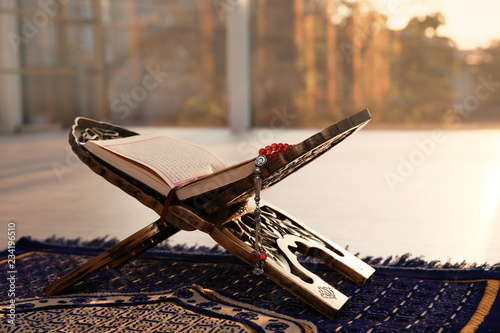 Canvas Print Rehal with open Quran and Muslim prayer beads on rug indoors