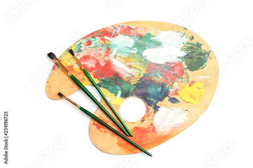 Wooden palette with brushes on white background, top view. Painting equipment for children