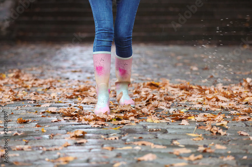 Woman wearing rubber boots after rain, focus on legs. Autumn walk © New Africa