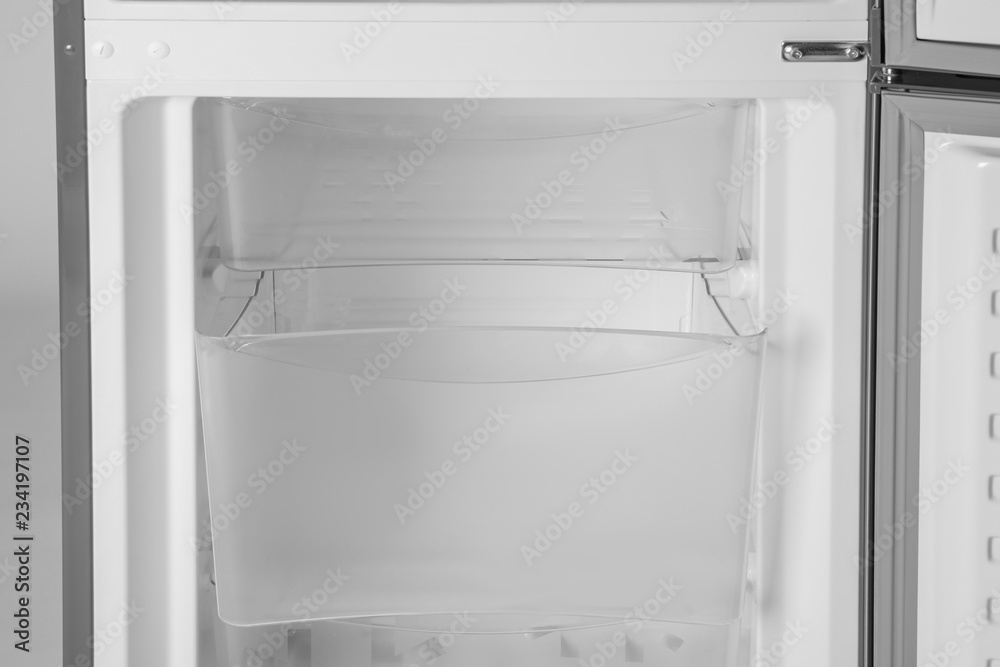 Modern open refrigerator with empty shelves, closeup Modern open refrigerator with empty shelves, closeup