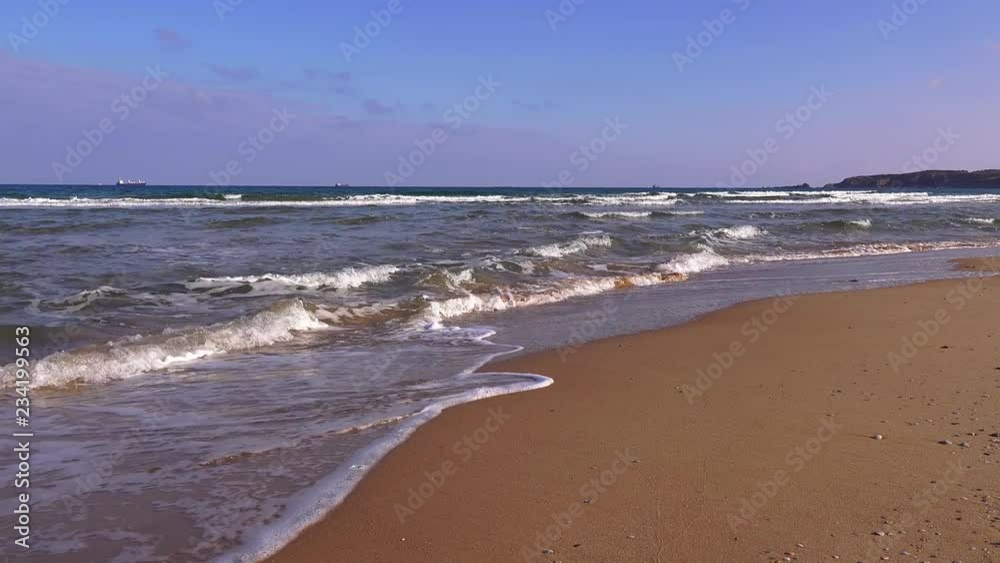 Seascape. Waves rolling on a sandy beach on a sunny day Seascape. Waves rolling on a sandy beach on a sunny day