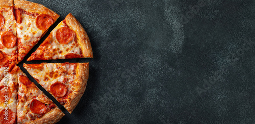 Canvas Print Tasty pepperoni pizza and cooking ingredients tomatoes basil on black concrete background