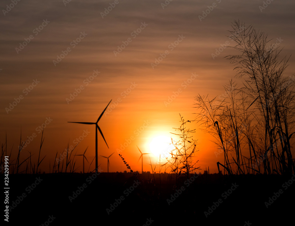 Silhouette wind turbine and grass field with twilight Silhouette wind turbine and grass field with twilight