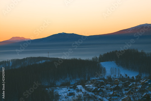 Village in a mountainous area at sunset. © esalienko