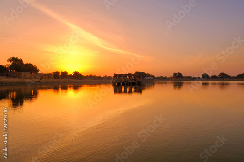 Amazing panoramic view of Gadisar or Gadi Sagar Lake with the view of historical building and temple during sunrise in Jaisalmer, India. © muslian