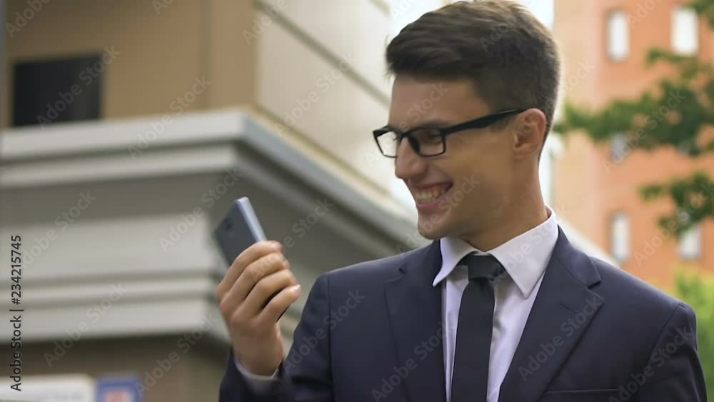Happy smiling man in suit talking smartphone on city street, profitable contract Happy smiling man in suit talking smartphone on city street, profitable contract