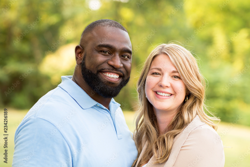 Loving mixed race couple hugging and laughing. Loving mixed race couple hugging and laughing.