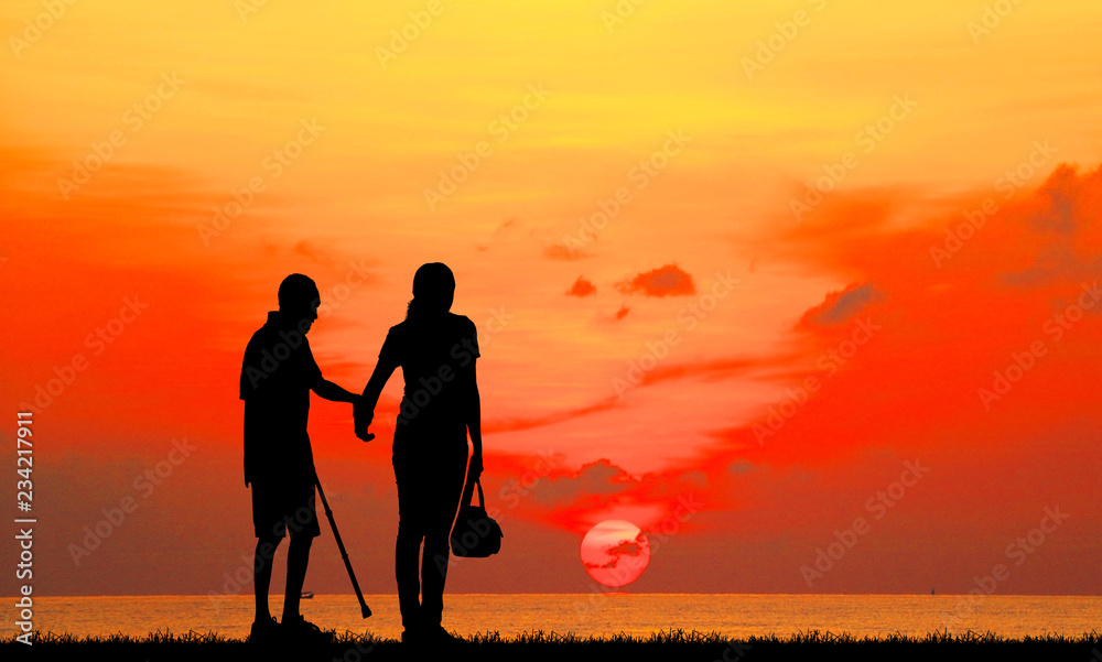  silhouette of the old man and Daughter   walk  in the park    on sunrise background