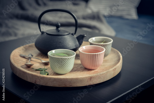 Black iron asian tea set on wooden tray