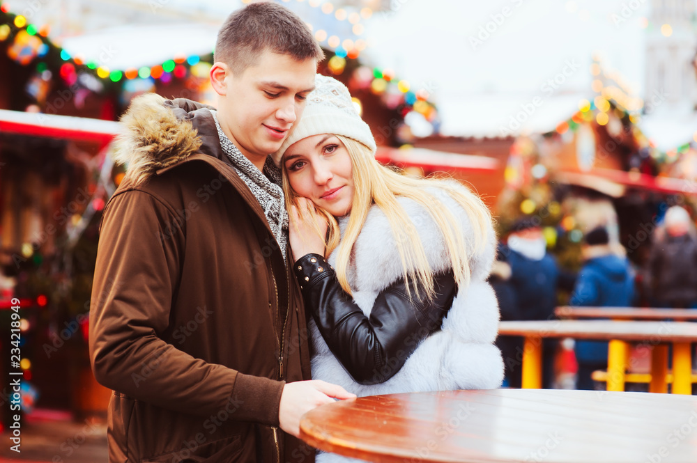 happy loving couple enjoying Christmas or New year Holidays outdoor, walking on city festive market with street food happy loving couple enjoying Christmas or New year Holidays outdoor, walking on city festive market with street food