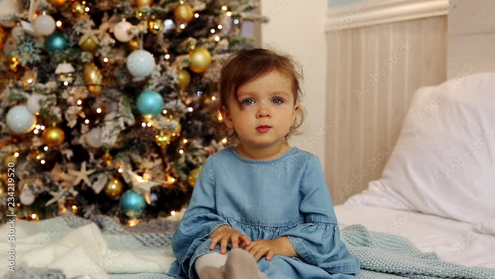 Little cute girl sits, smiles and waves her hand Little cute girl sits, smiles and waves her hand