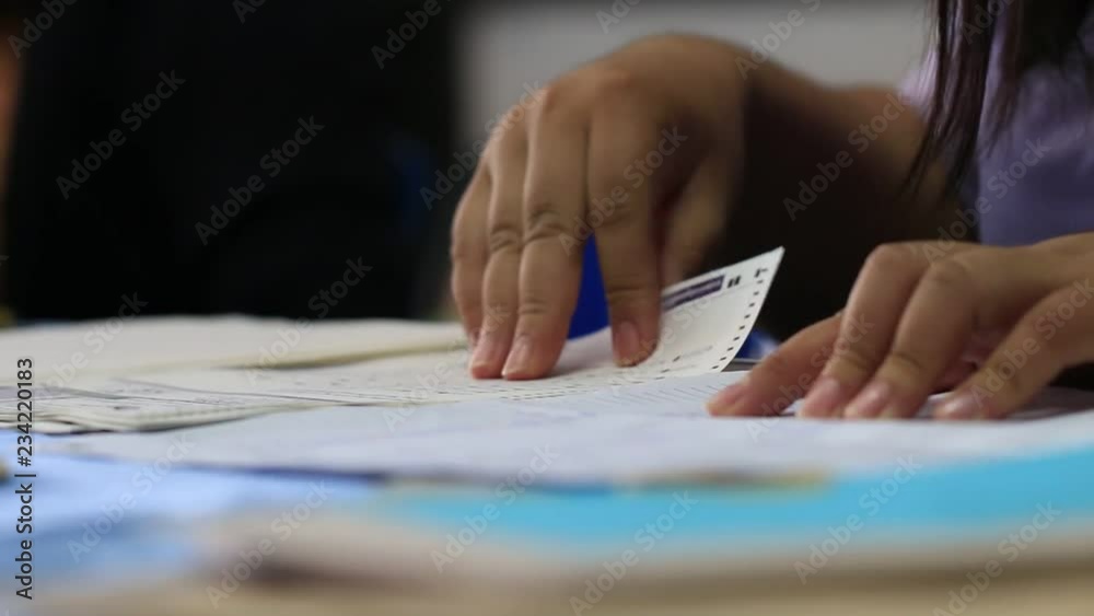 Businesswoman working checking reports information in tablet with Stack unfinished documents paper report files on busy overwork desk. Business management concept