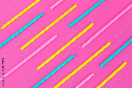 Drinking straws on bright pink background, top view