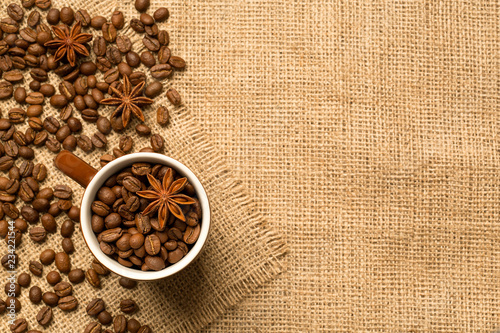 Coffee cup and ingredients on burlap background