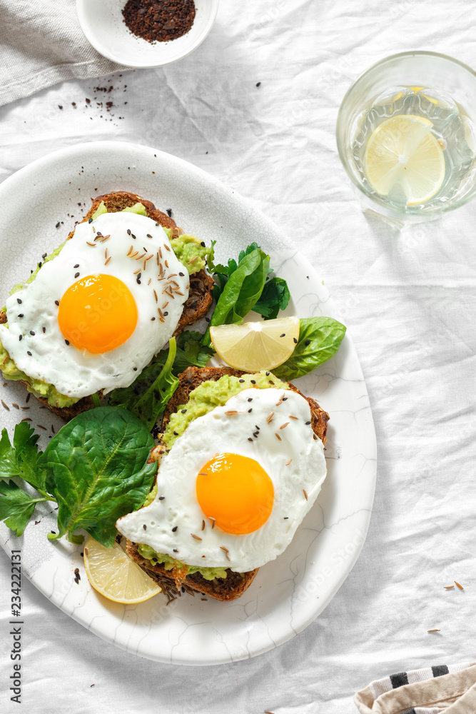 Top view healthy avocado toasts breakfast lunch fried eggs white background lemon water Top view healthy avocado toasts breakfast lunch fried eggs white background lemon water