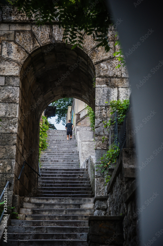 Running man in old city stone steps