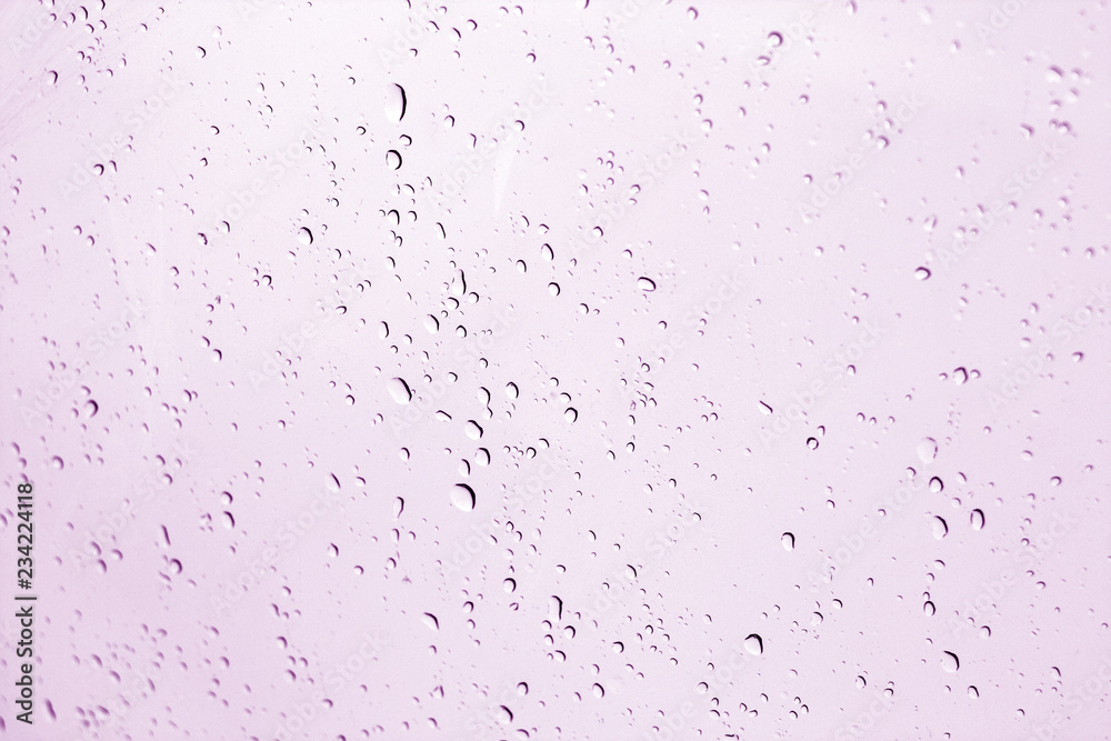 Blured water drops on window in purple tone.