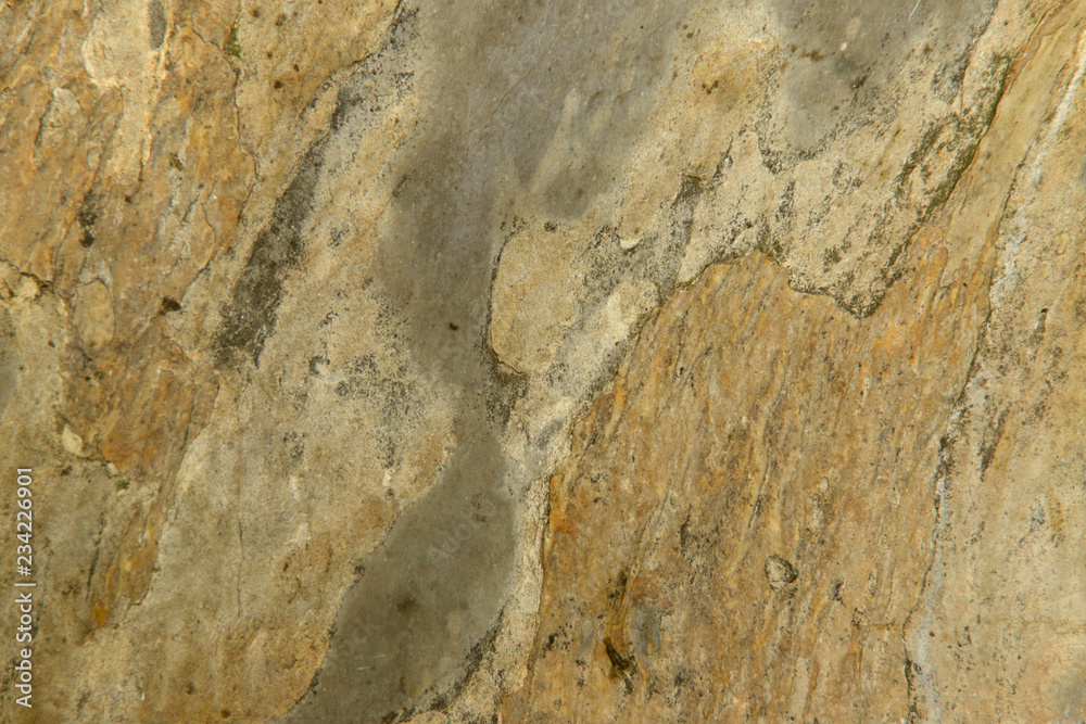 Natural abstract background. The texture of the old yellow stone wall with chinks. Cropped shot, close-up, nobody, vertical. Concept of history and construction.
