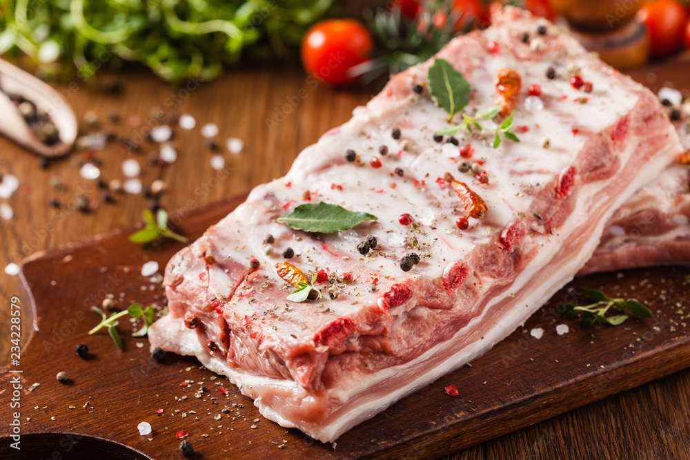 Raw pork ribs, on a plate sprinkled with spices. Raw pork ribs, on a plate sprinkled with spices.