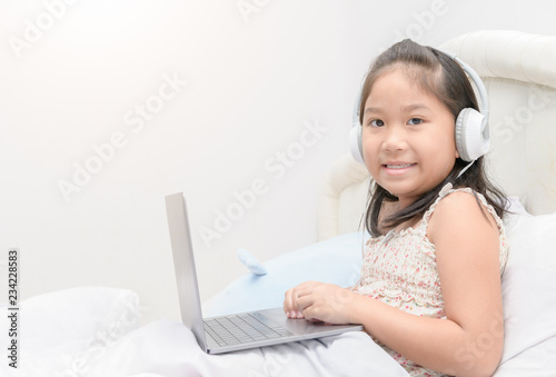 Cute girl play laptop and listening music