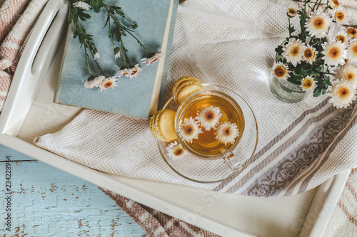 Foto Cup of tea, macaroons, chrysanthemum flowers and books