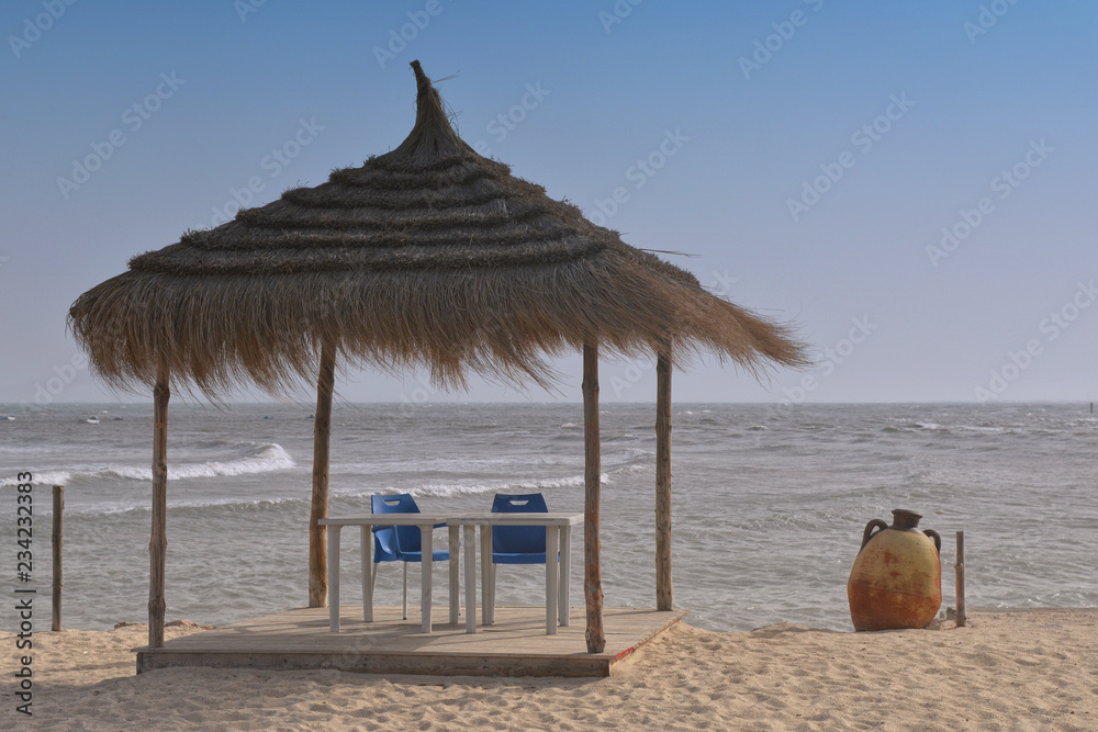 Tunisia, Djerba - Aghir. Beach and sand, parasol.