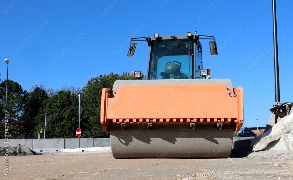 Asphalt paving machine in a road construction site. Front view of its roller with copy space