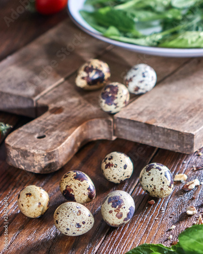 Quail eggs and greens in a plate on a wooden table. Ingredients for Making Healthy Salad