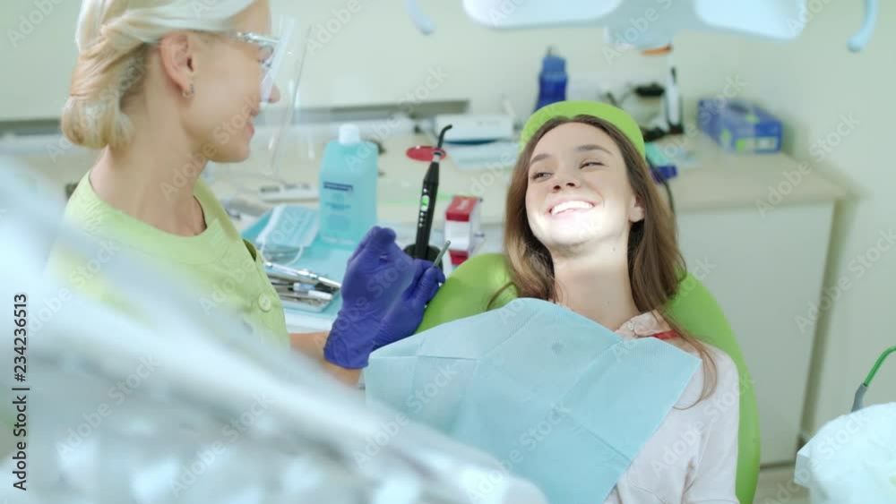 Woman on regular dental checkup in dentist office. Happy girl in dental chair Woman on regular dental checkup in dentist office. Happy girl in dental chair