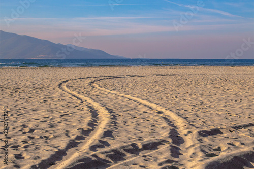 Traces in the sand. Morning landscape on the beach of Keramoti, Aegean Sea, Greece.