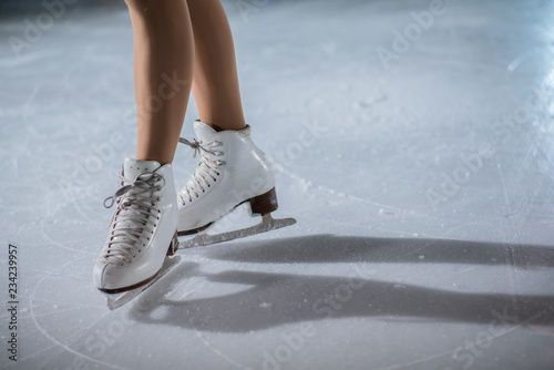 A young girl in her initial position before her show on the ice.