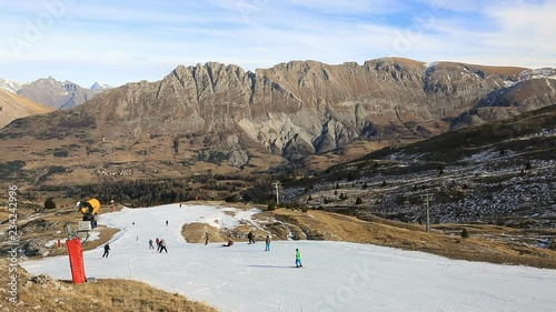 Footage of unidentified people skiing on a slope with artificial snow.