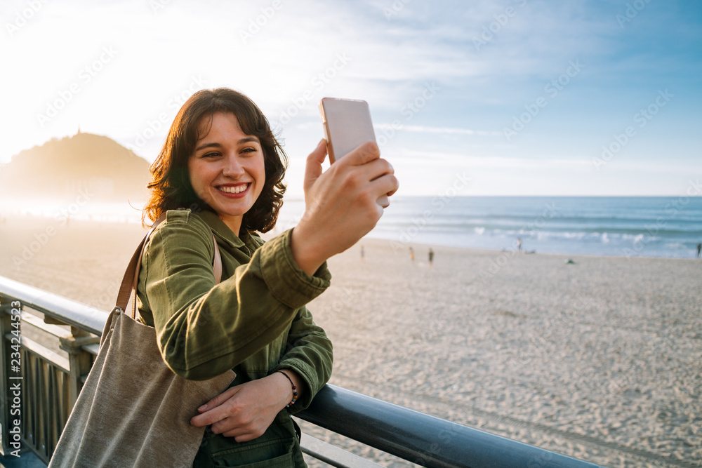 Fototapeta premium Happy tourist woman taking selfie with her smart phone
