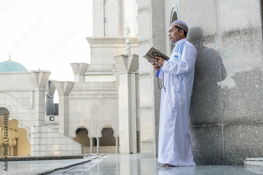 Middle age muslim man praying at mosque.