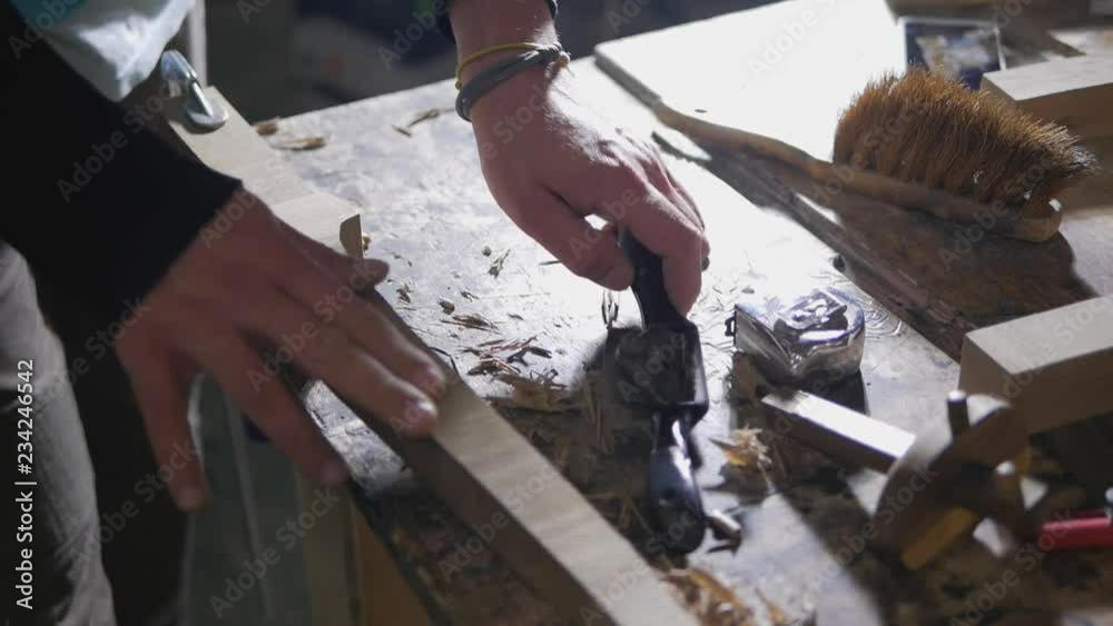 a woodworker planes a cabriol leg of walnut wood shavings a woodworker planes a cabriol leg of walnut wood shavings