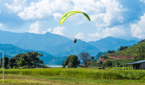 Bild auf Leinwand paraglider that flies over meadow, Pokhara region, Nepal