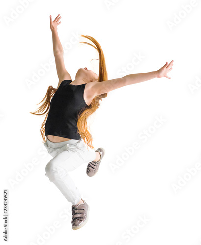 Fototapeta Naklejka Na Ścianę i Meble -  Excited young girl leaping in the air with her hands raised. Sport, training, dancing lifestyle.