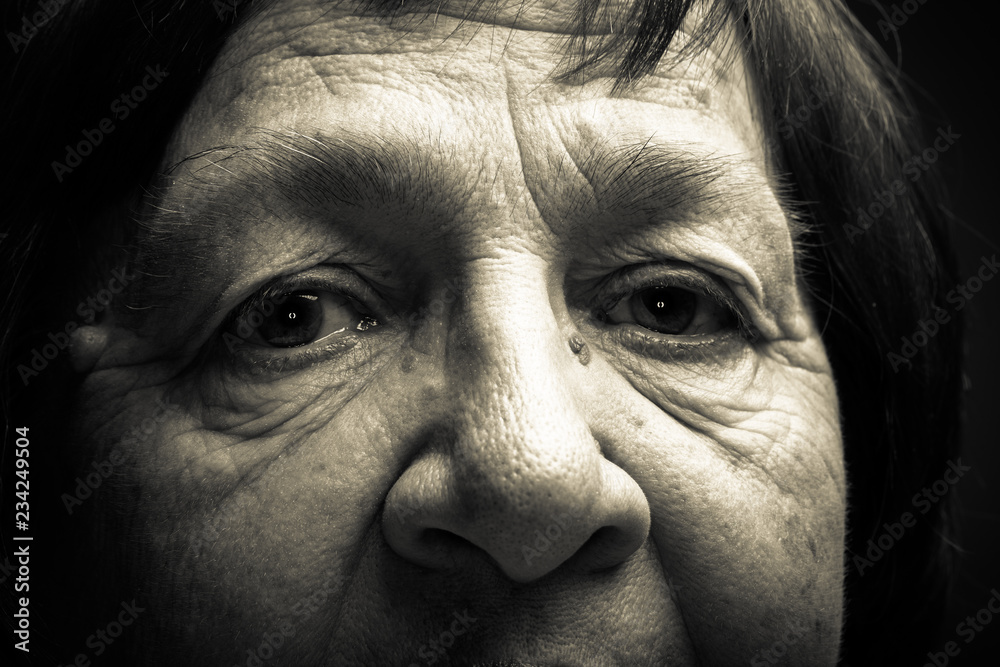 Close up studio portrait of elderly woman with hat. Sad. Toned Close up studio portrait of elderly woman with hat. Sad. Toned