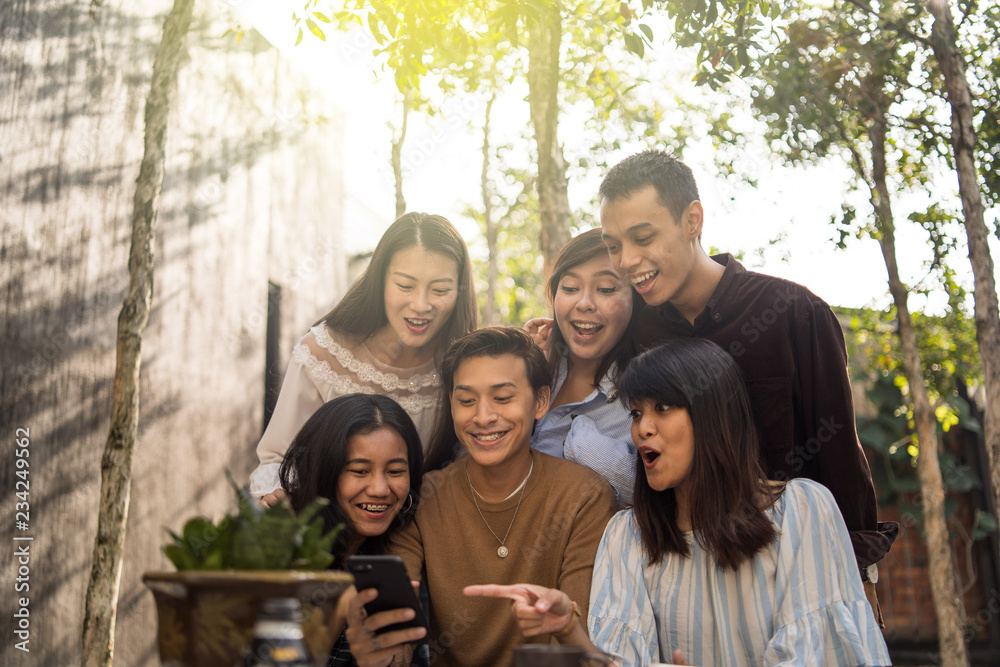 asian friends chilling outdoor with smartphone asian friends chilling outdoor with smartphone